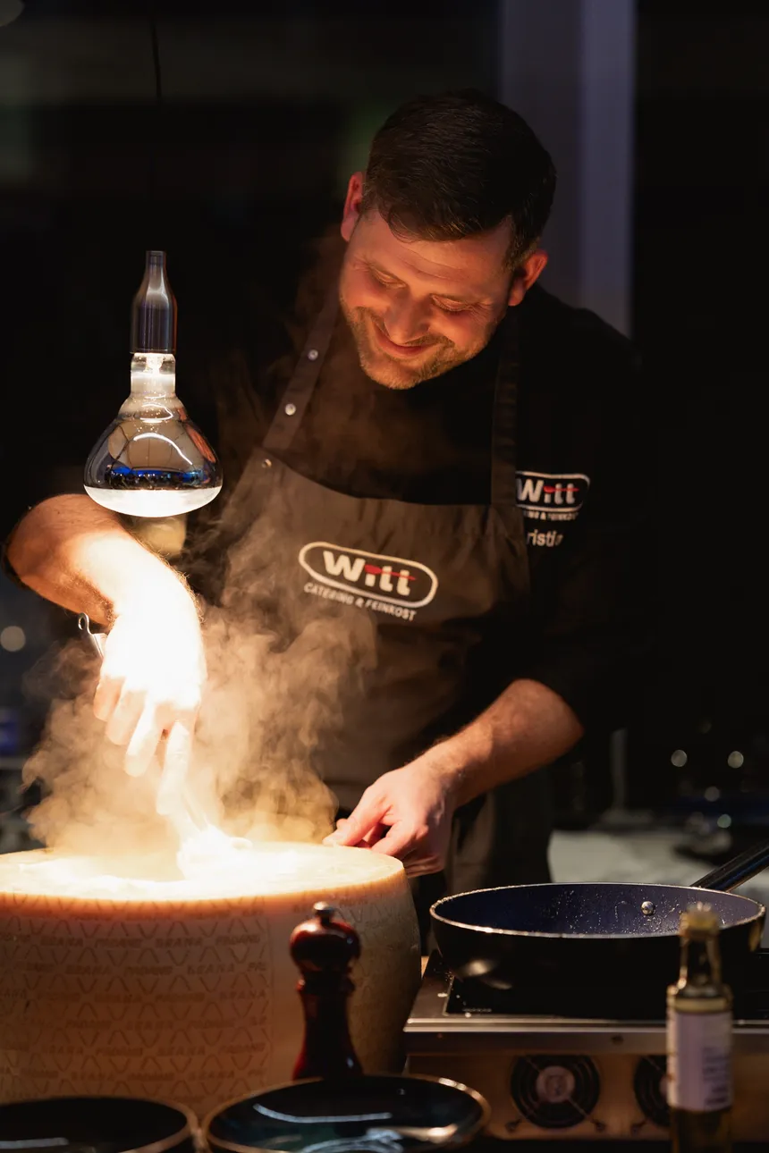 Christian Witt am Parmesan-Laib unter Wärmelampe